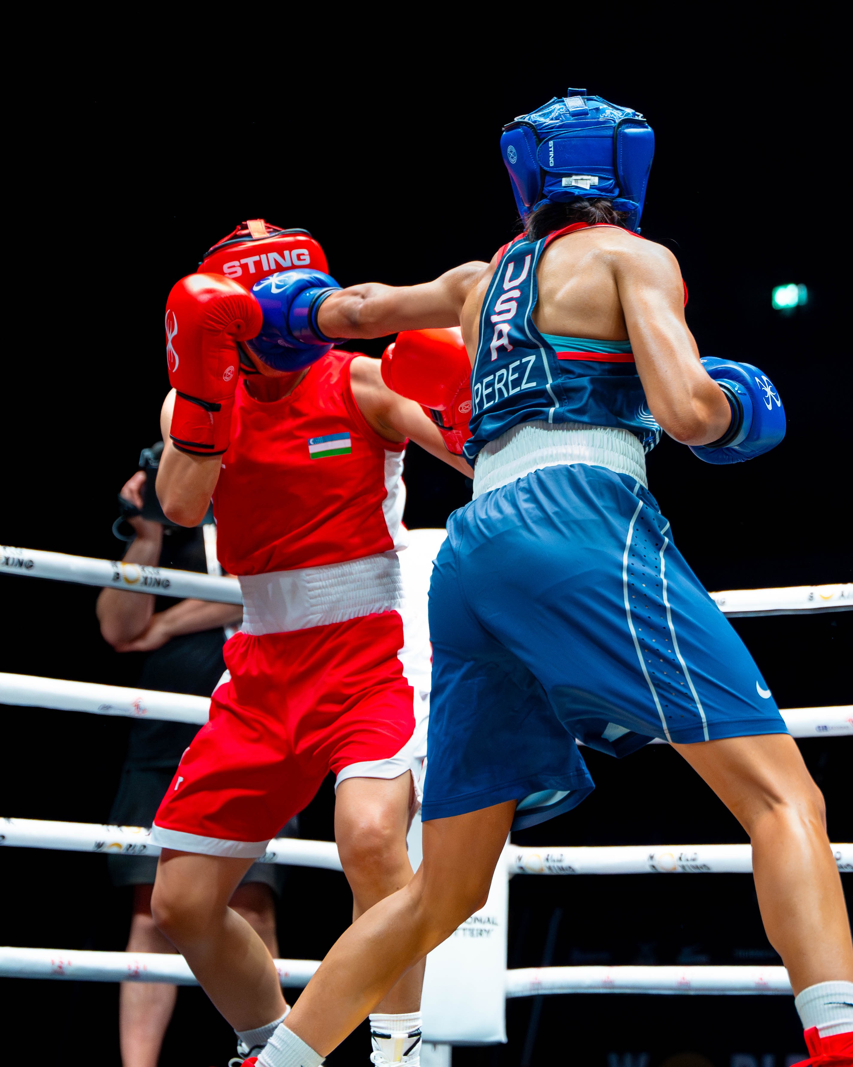 Yoseline Perez jumping mid-air in red kit during a ring walkout in Liverpool