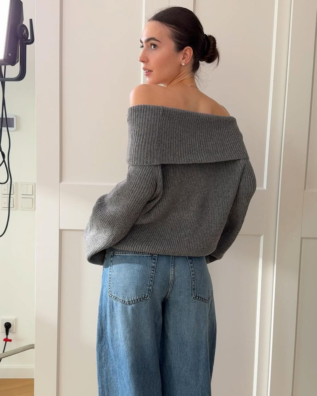 Tetiana Soviak in a grey off-shoulder sweater and wide leg jeans
