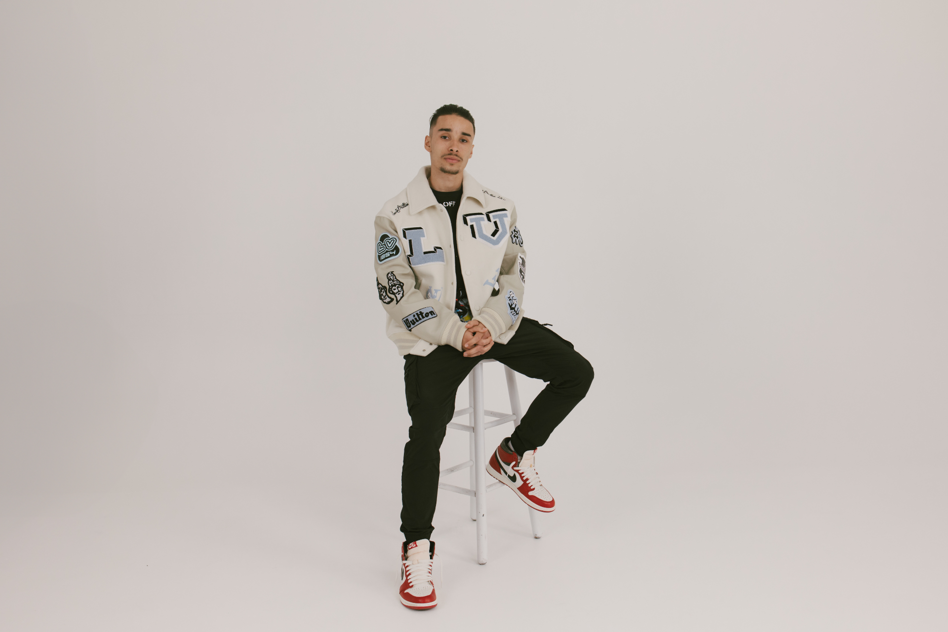 Niko Schultz in a studio portrait wearing a varsity jacket