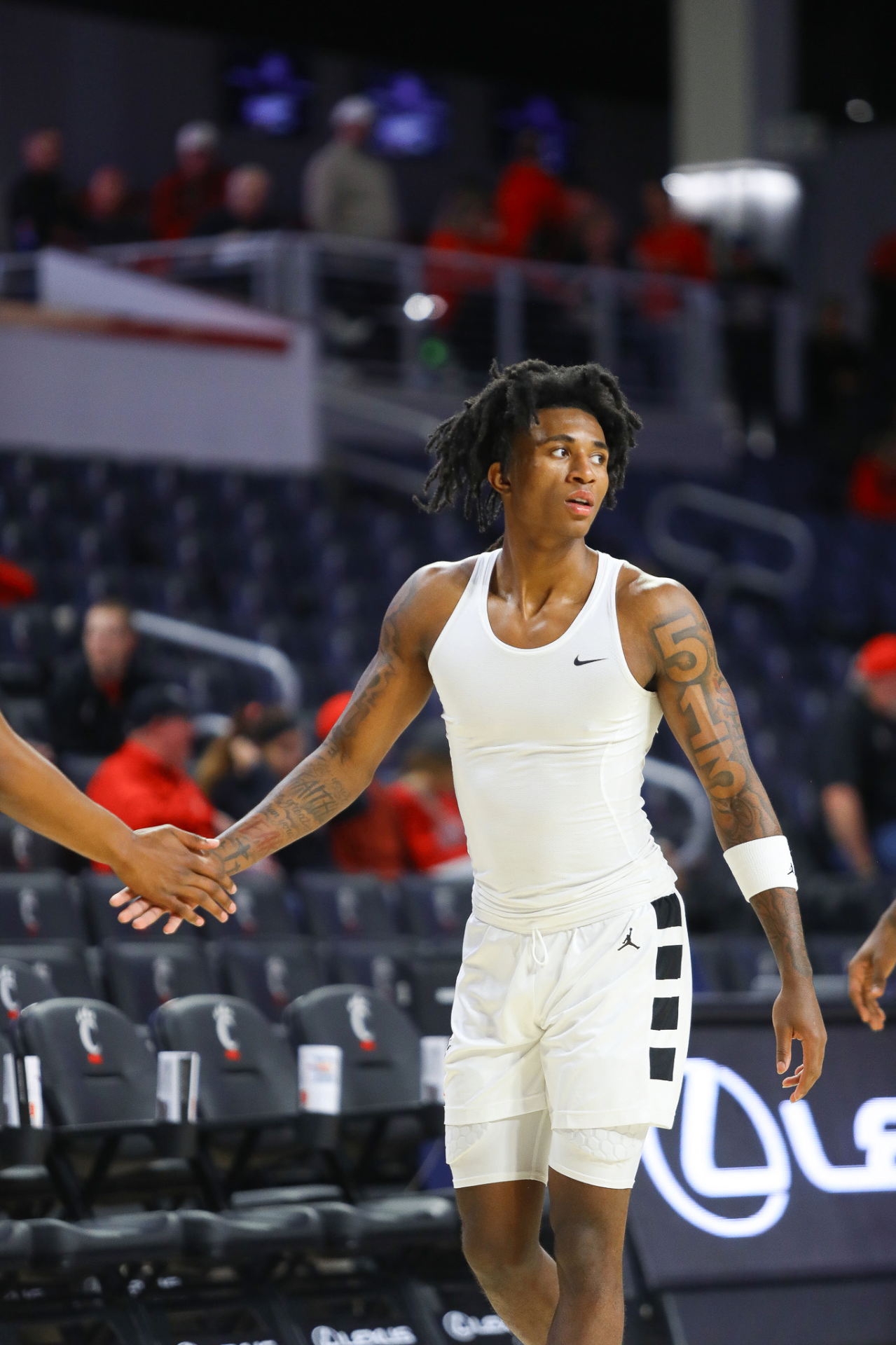 Rayvon Griffith on court during warmups greeting a teammate