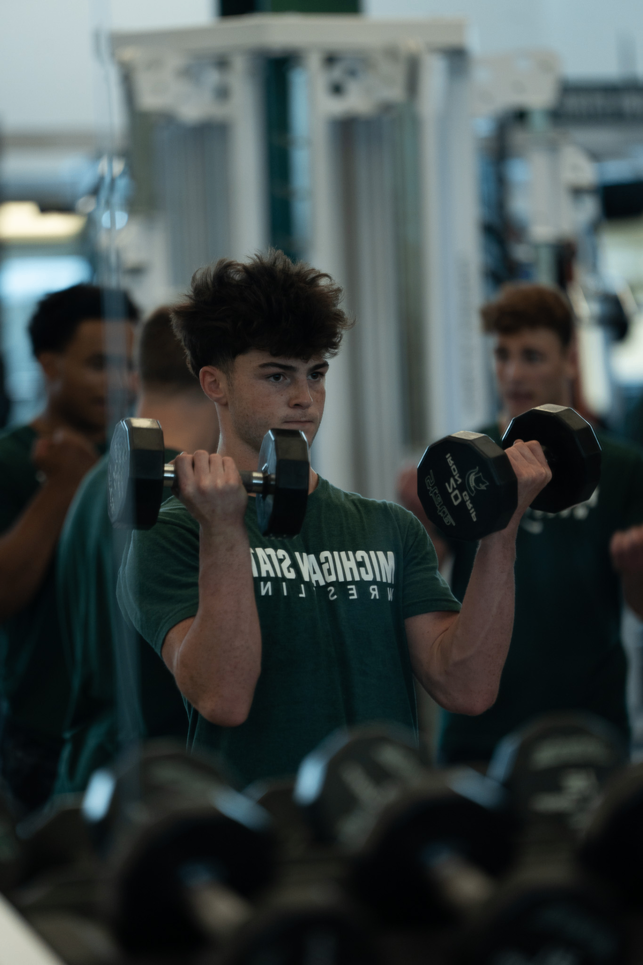 Sammy Agnello lifting dumbbells in a Michigan State Wrestling shirt