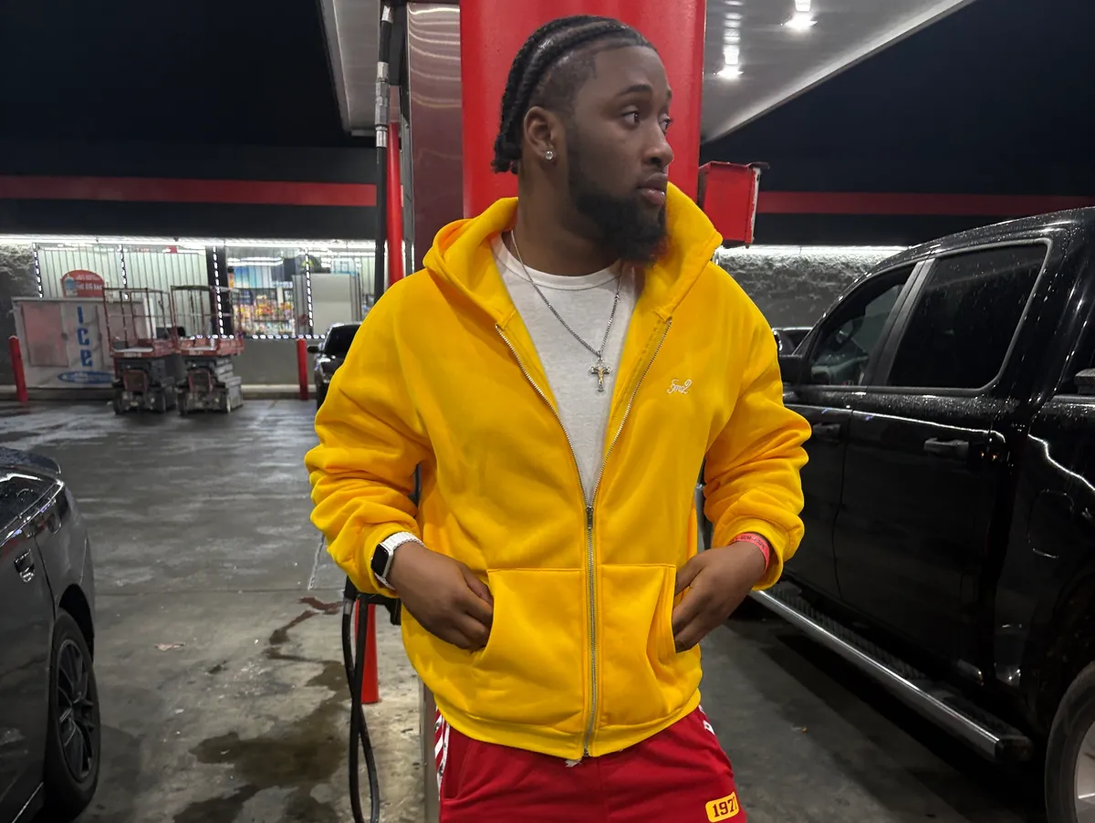 Andre Tibbs Jr in a yellow hoodie at a gas station at night