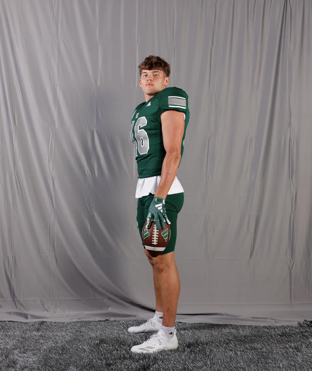Noah Knigga in full Eastern Michigan football uniform holding a football