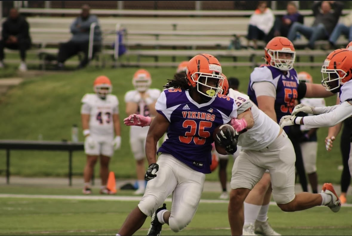 Kylan Wallace carrying the football in a Vikings uniform during a game