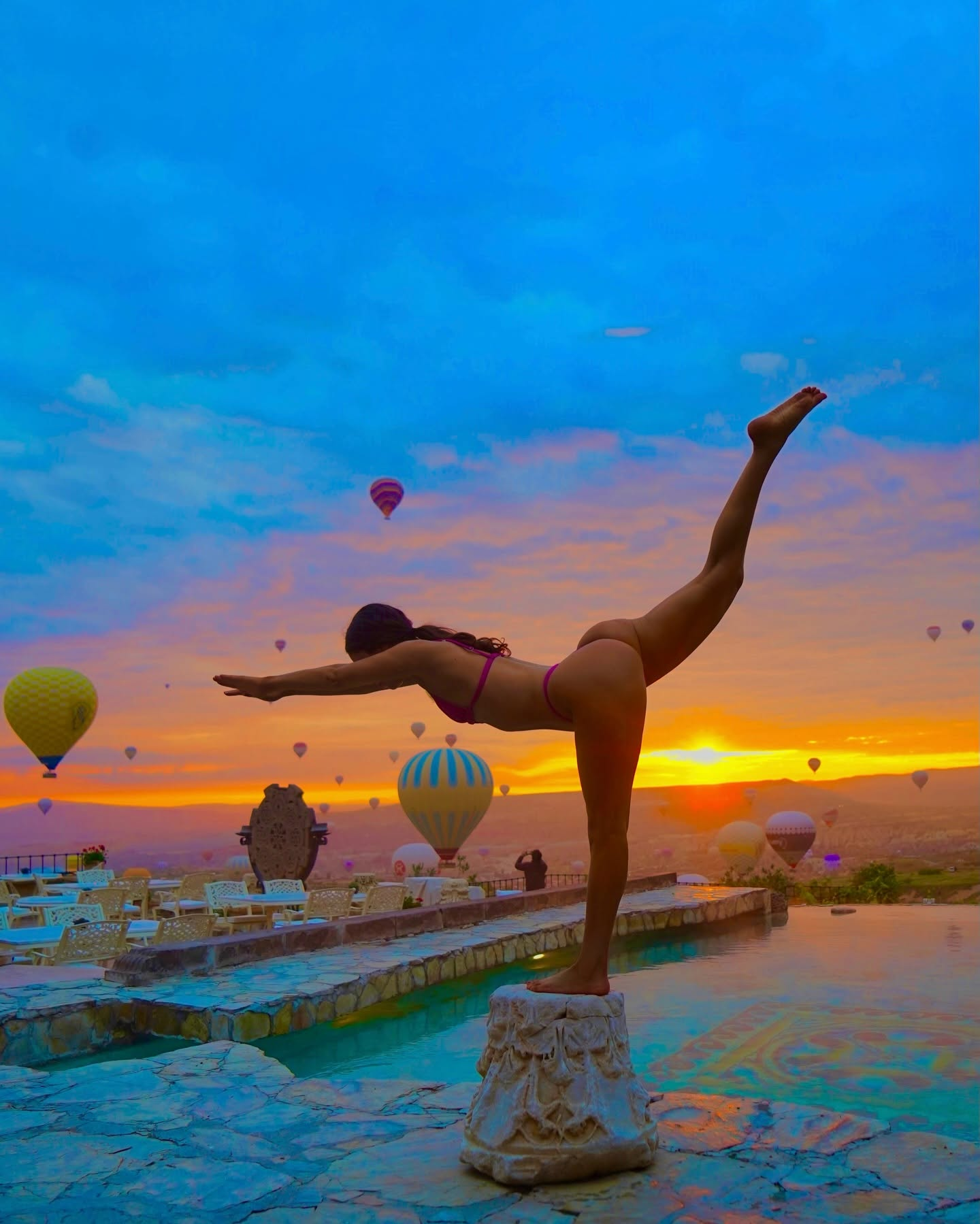 Jen Selter in a poolside arabesque against a Cappadocia sunrise with hot air balloons