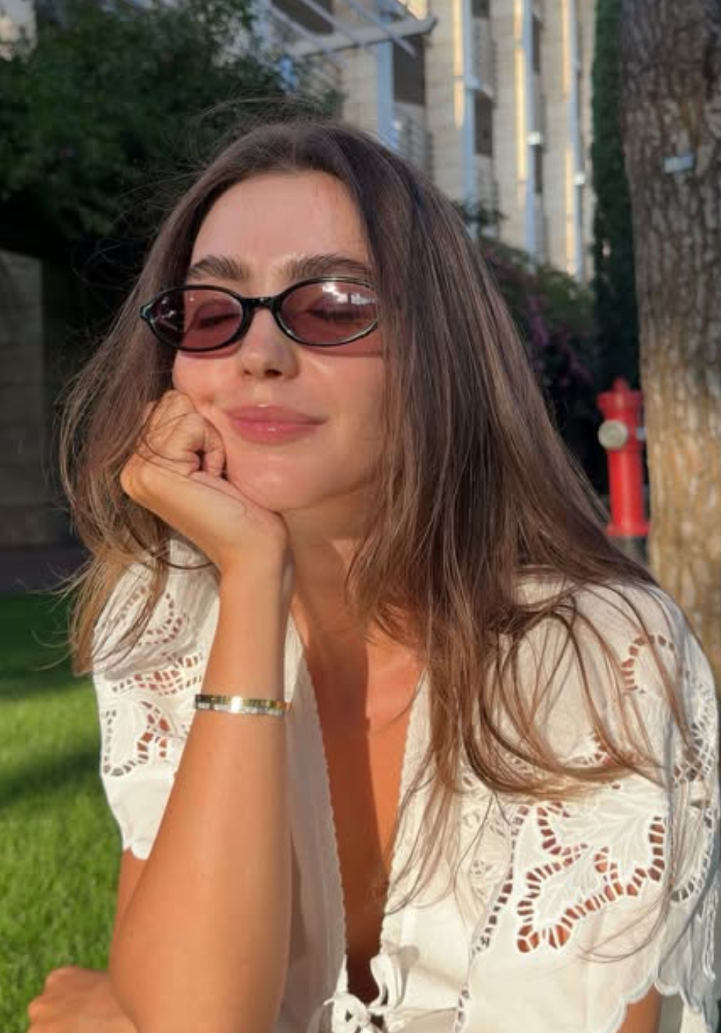 Tetiana Soviak in a white eyelet top with sunglasses