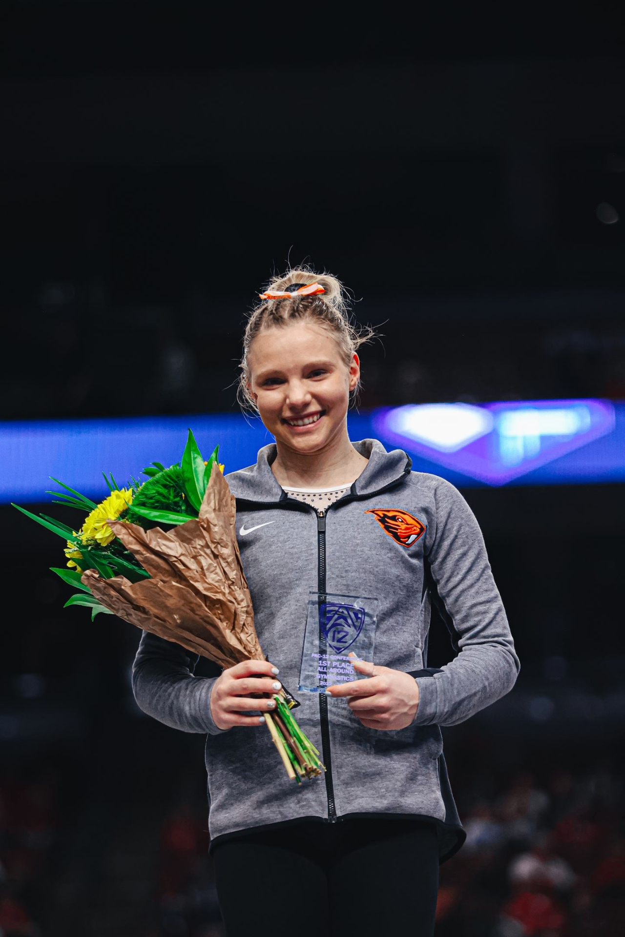 Jade Carey holding flowers and a Pac-12 first place all-around award in Oregon State gear