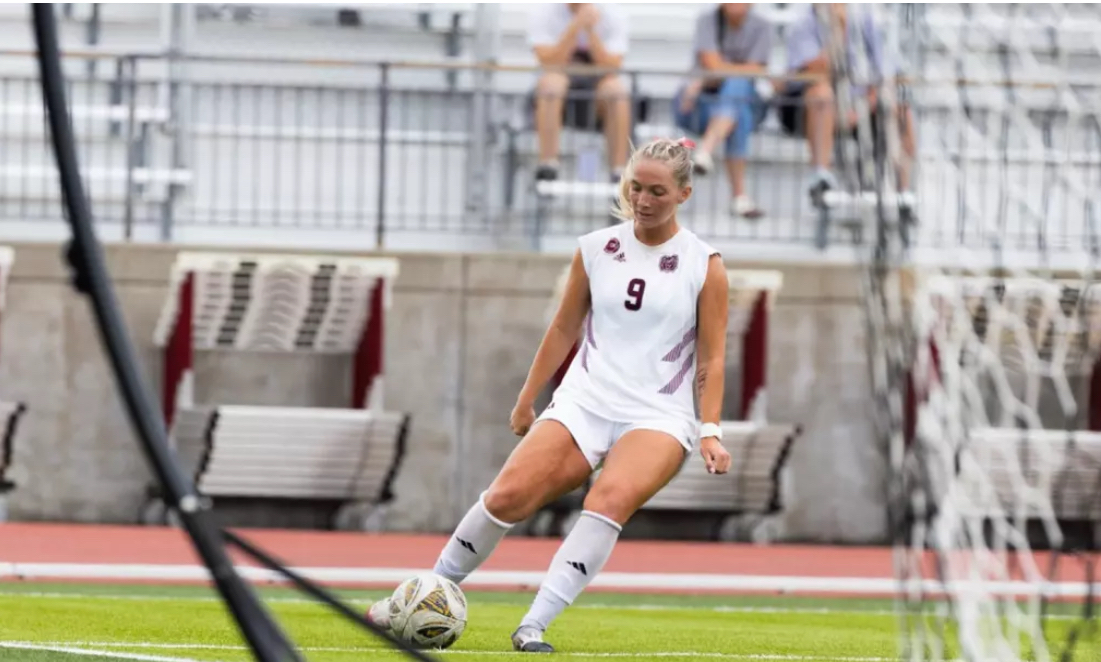 Macee McKenna in a Missouri State white #9 jersey lining up a pass in front of the goal