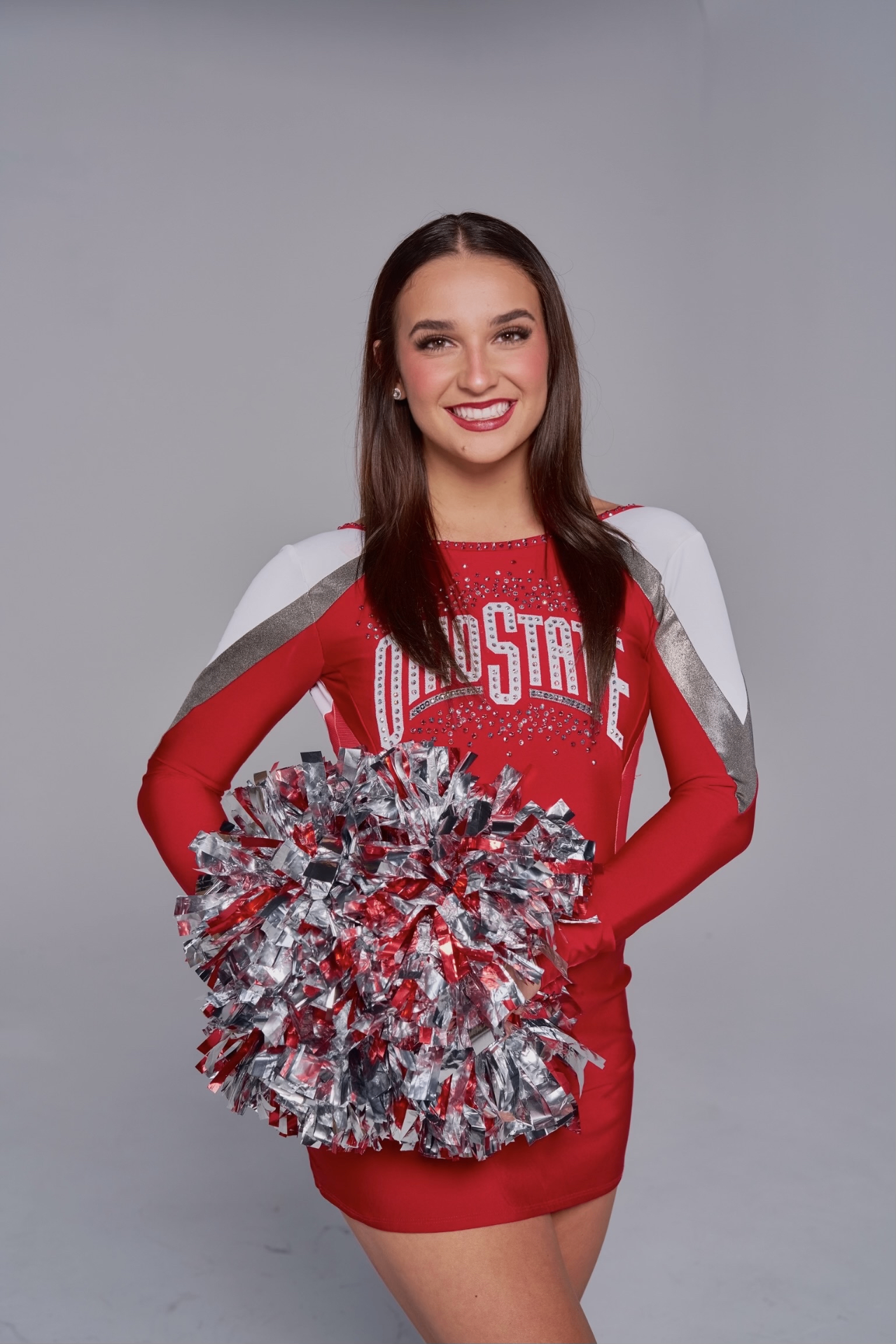Emma Hellenkamp studio portrait in Ohio State red uniform holding pom poms