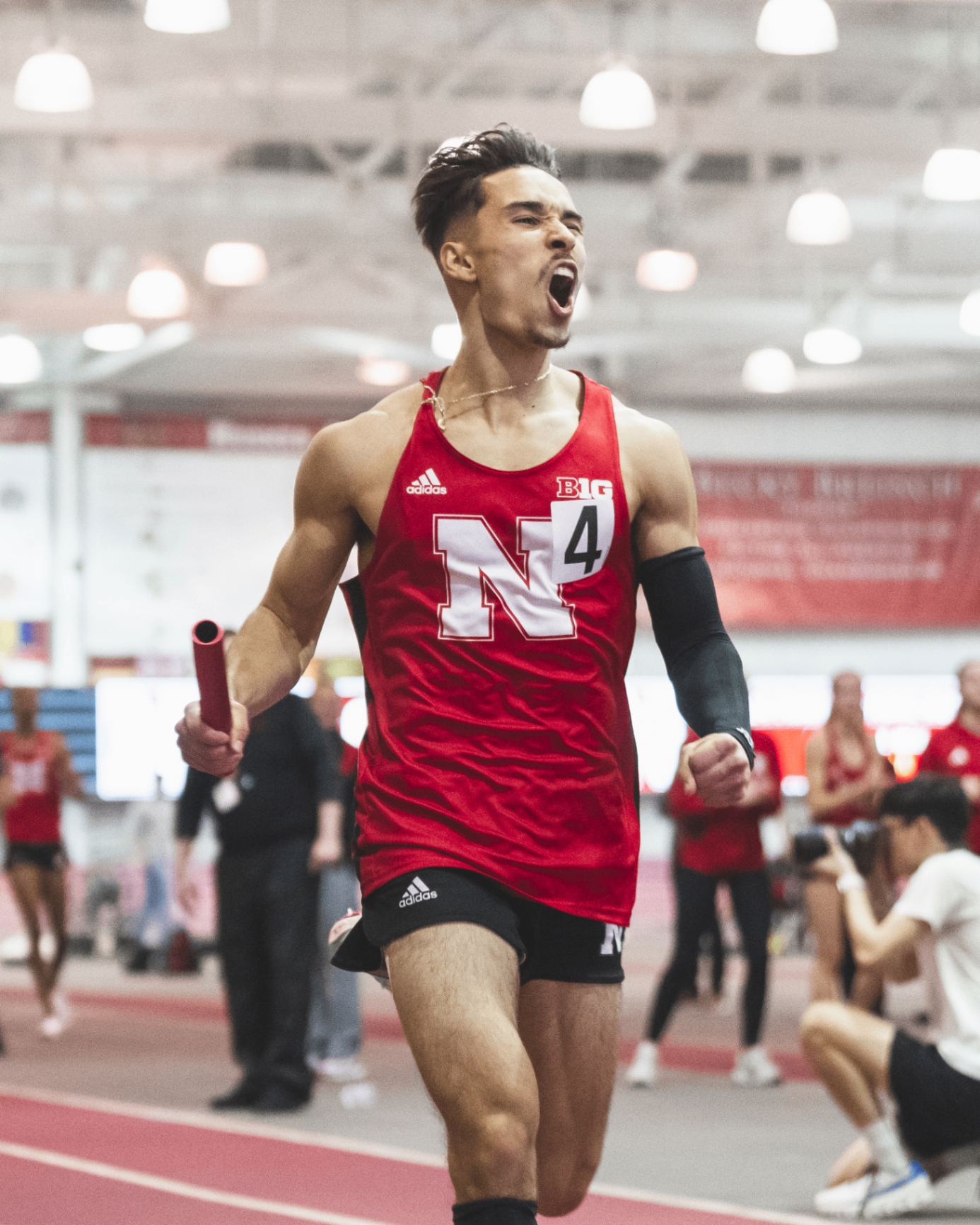 Niko Schultz celebrating indoors in Nebraska relay gear