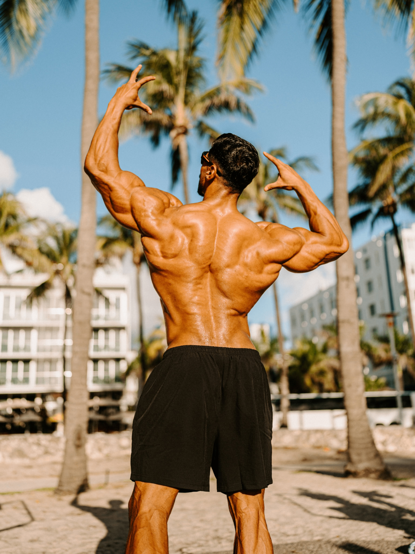 Andrei Deiu posing on a palm-lined beach