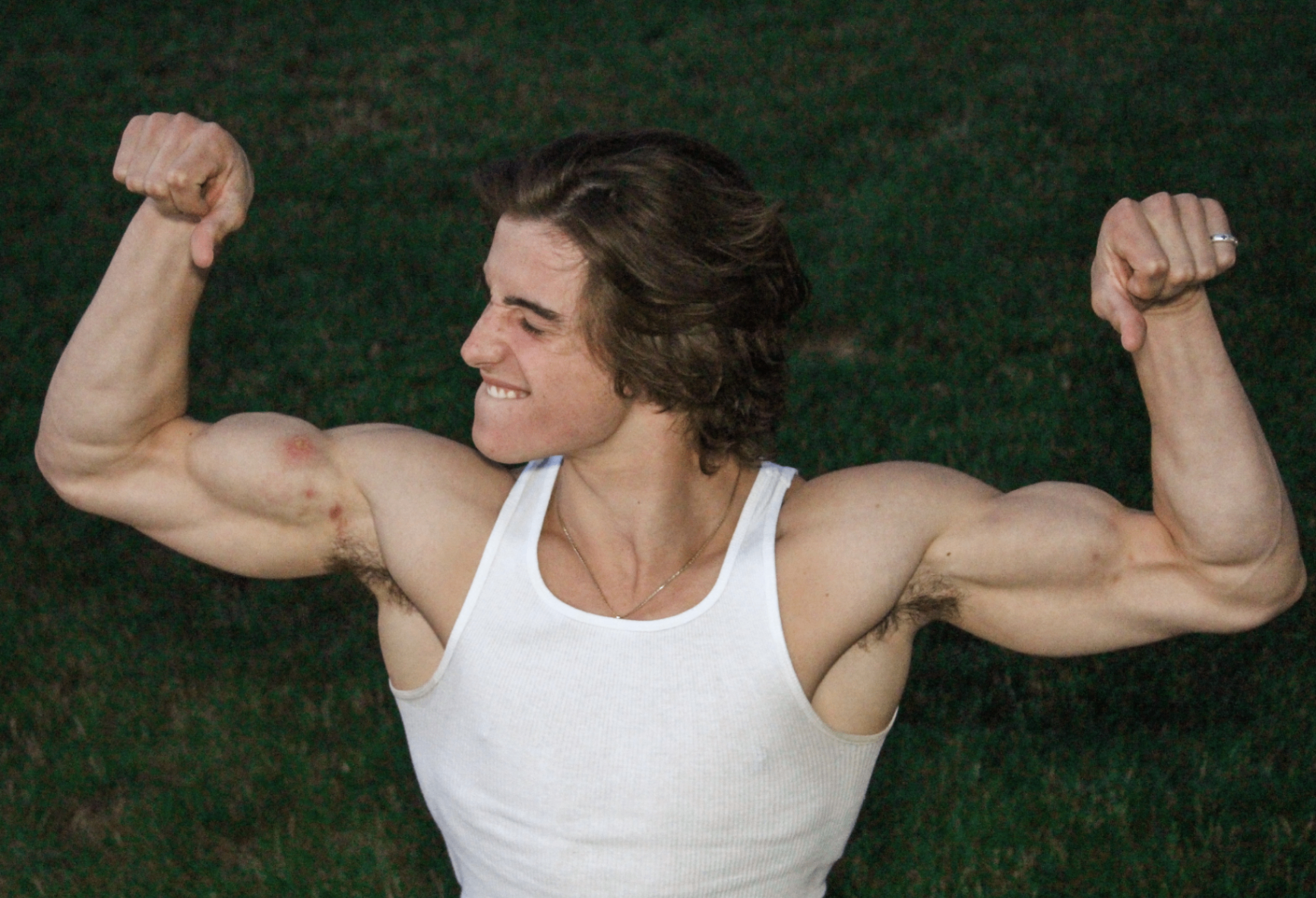 Michael Jaroh flexing in the grass at sunset