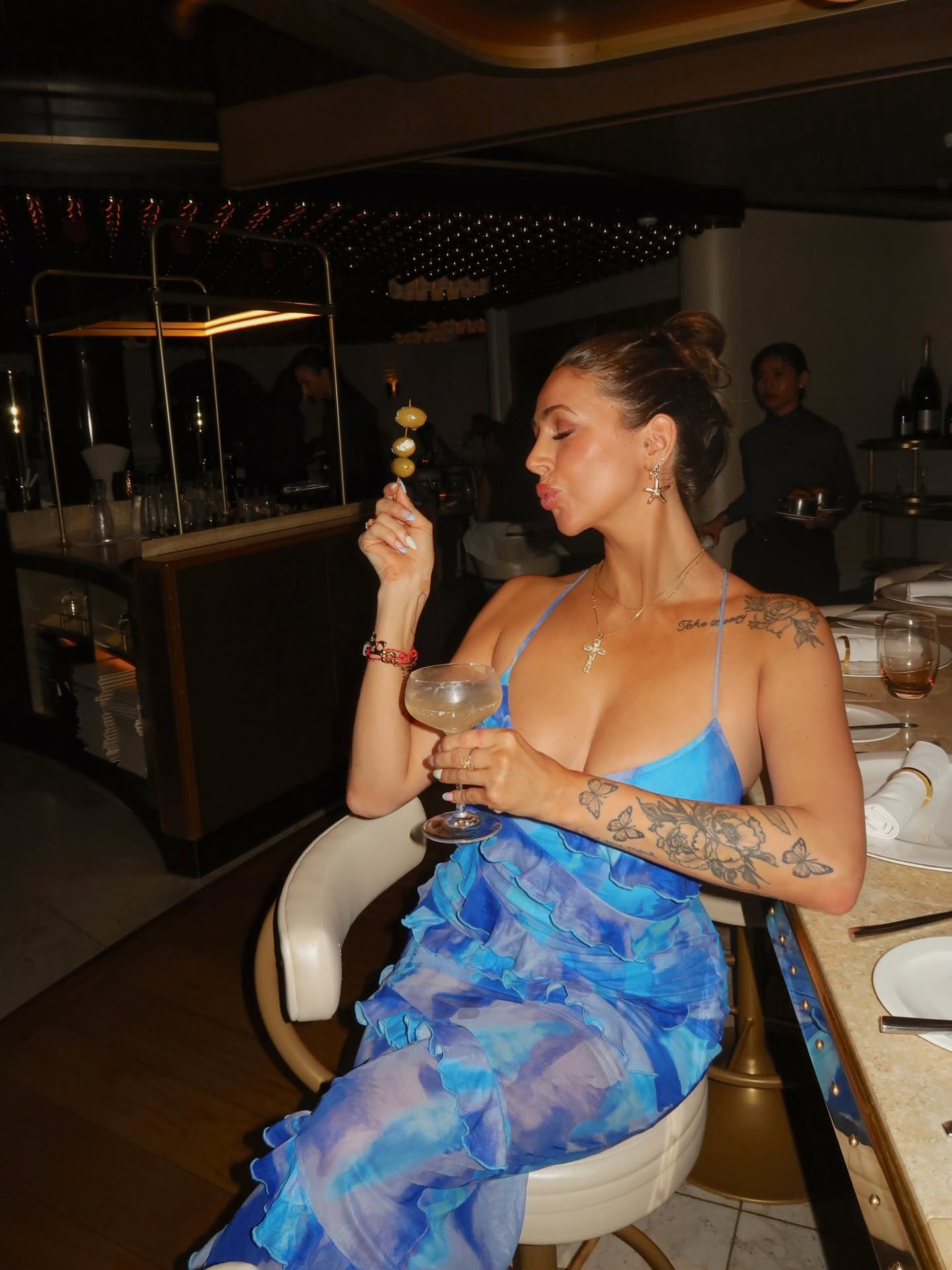 Bri Maloney in a blue dress at a luxury restaurant
