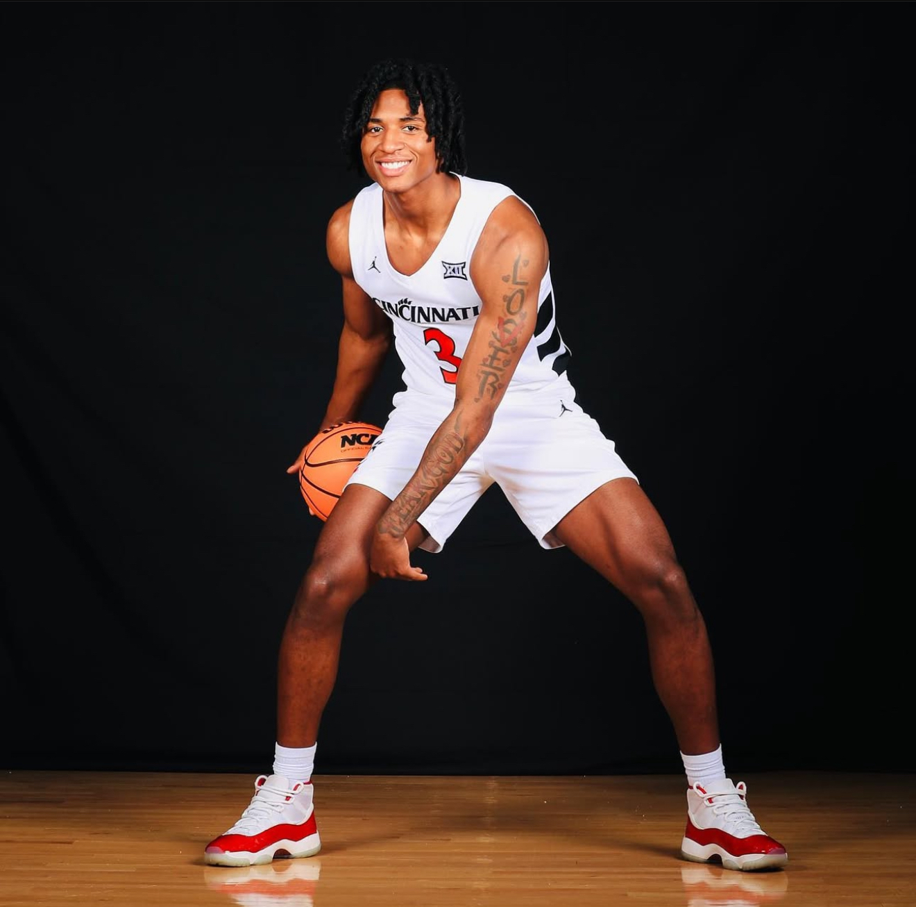 Rayvon Griffith in studio pose with basketball