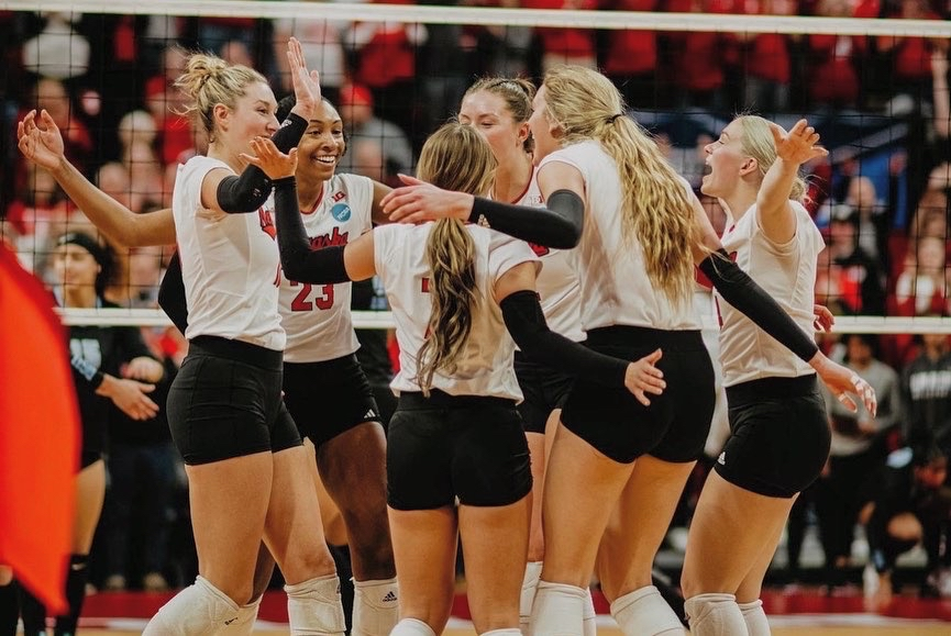 Maisie Boesiger huddled with her Nebraska teammates at the net