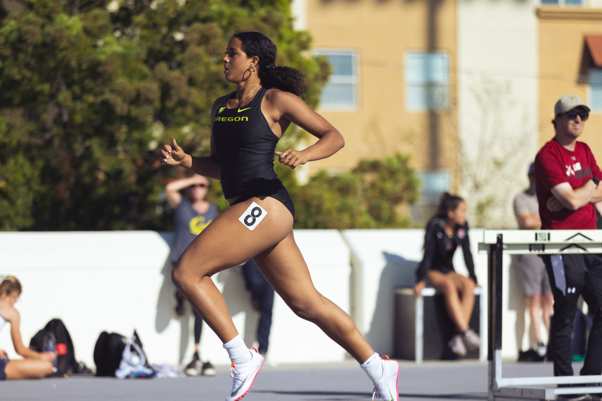 Gianna Bullock sprinting in Oregon black competition kit