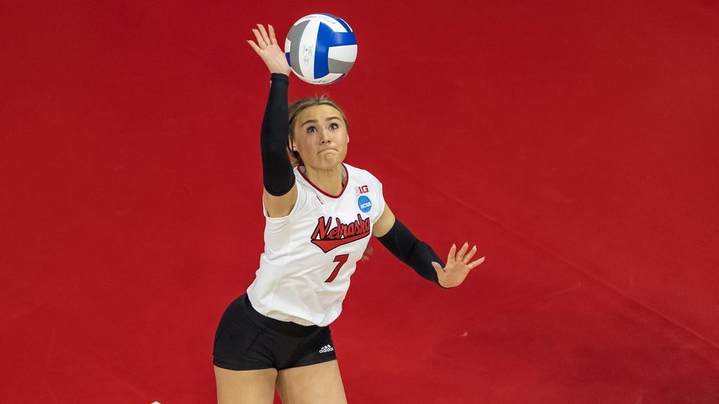 Maisie Boesiger serving the volleyball in her Nebraska #7 jersey