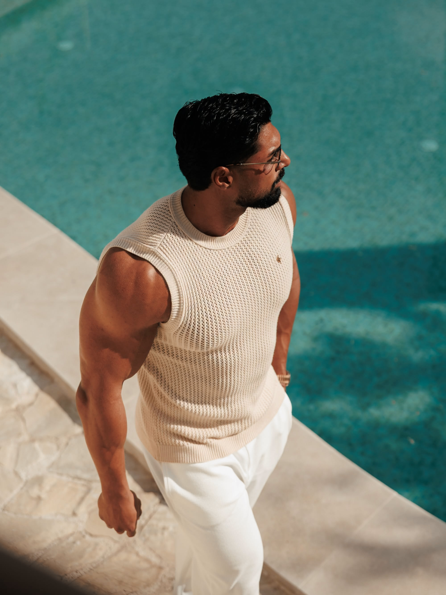 Andrei Deiu in a cream knit look by the pool